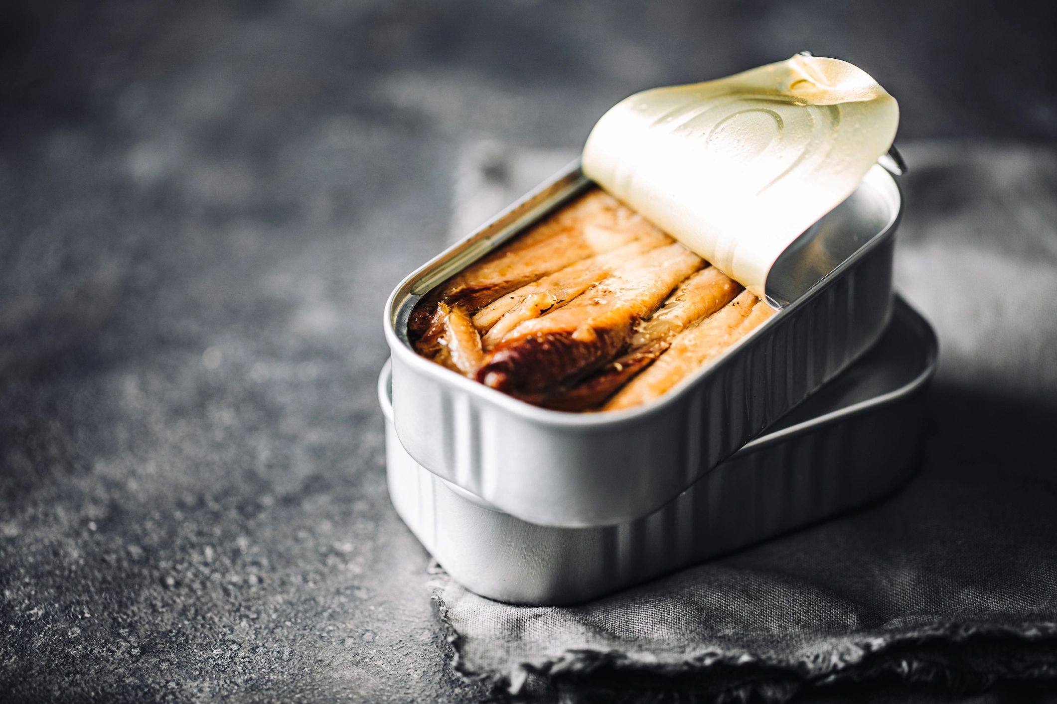 Open tin of sardines on a kitchen table